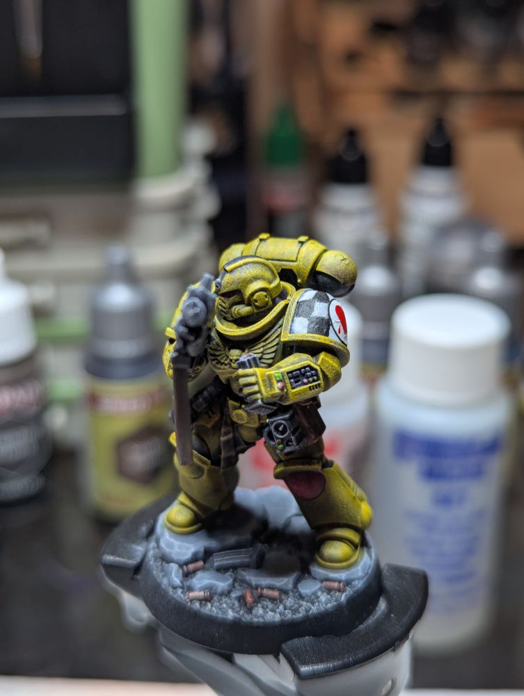 A Lamenters Sergeant, 2nd Squad, 3rd Company. He has a black stripe on his yellow helmet, indicating his status from the painting guides from many moons ago.