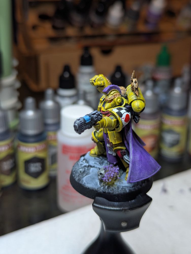 The Captain of the 3rd Company of the Lamenters, resplendent in his bright yellow armor and violet cape with bleeding heart iconography