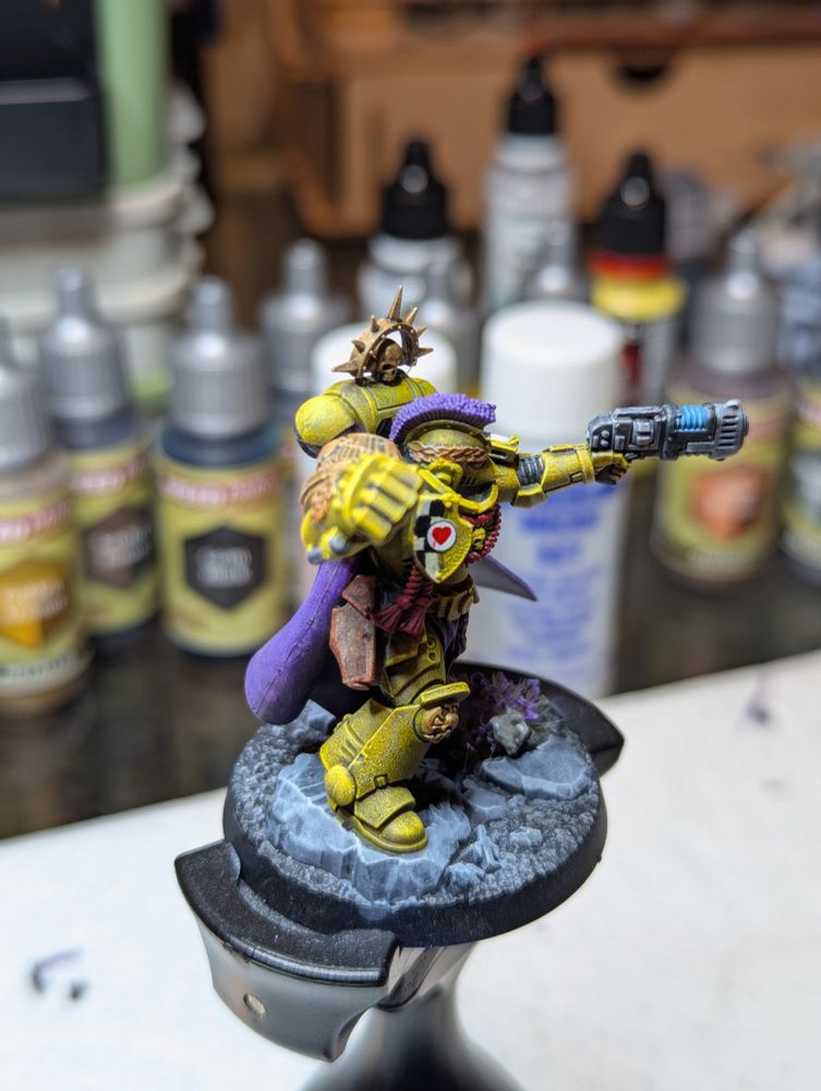The Captain of the 3rd Company of the Lamenters, resplendent in his bright yellow armor and violet cape with bleeding heart iconography