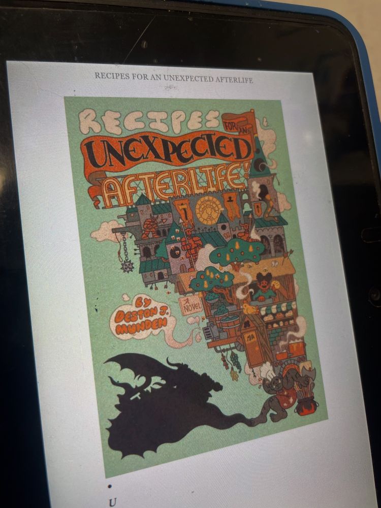 Picture of a kindle e-reader with the cover of the book “Recipes for an Unexpected Afterlife” shown on the screen. The book cover is a pale green background with a fantasy scene of castles buildings and various characters all bubbling out of a cauldron and held up by an orc in a chef hat. 
