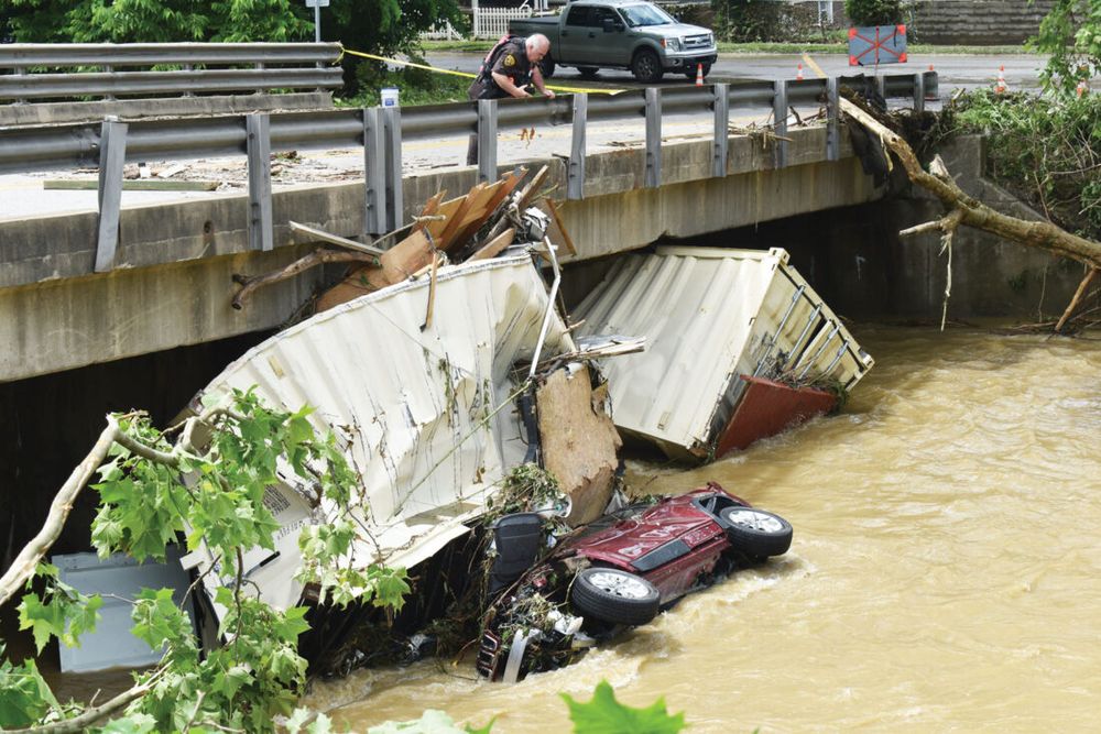 Photograph of massive flooding causing debris including cars and shipping containers to be wedged under the Shilling Bridge in Elm Grove.

Photo taken from this article: https://www.newsandsentinel.com/news/local-news/2025/06/ohio-county-deluge-five-confirmed-dead-in-wheeling-area-flooding/