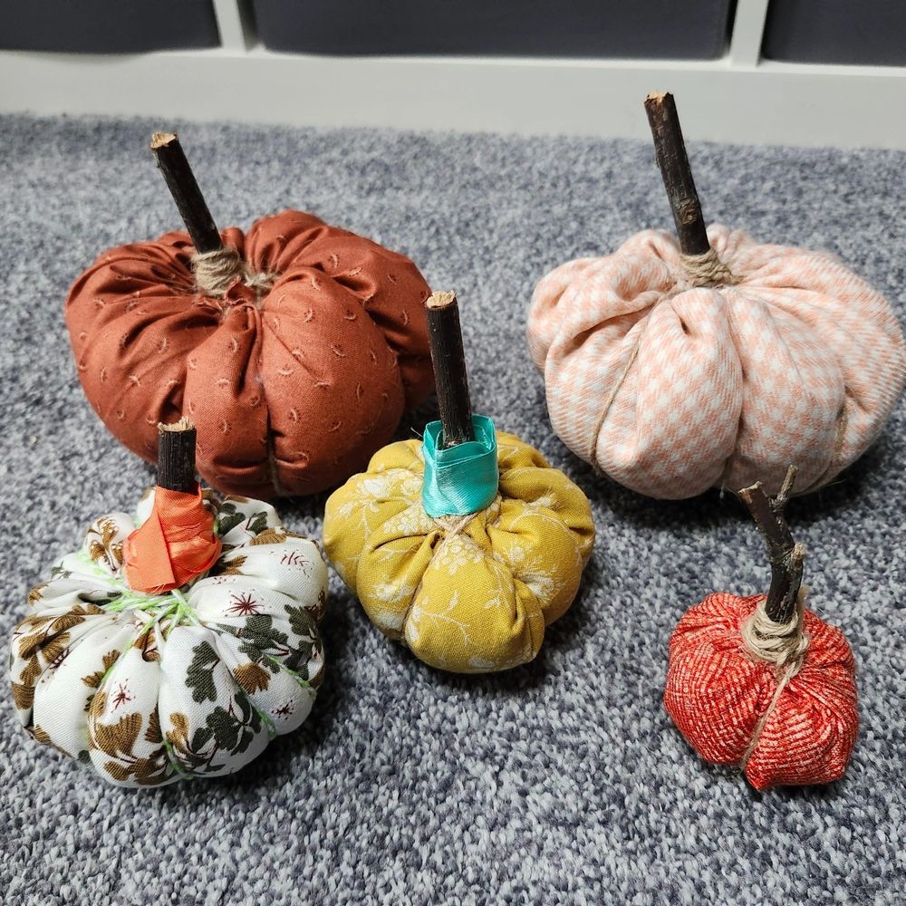 Pumpkins made out of fabric stuffed with stuffing and tied up with Twine and a stick.