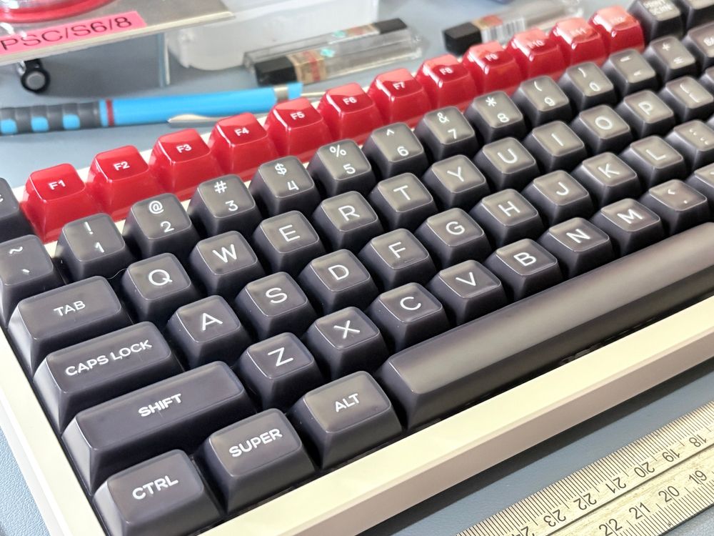 A beige keyboard with black basic keys and bright red function keys