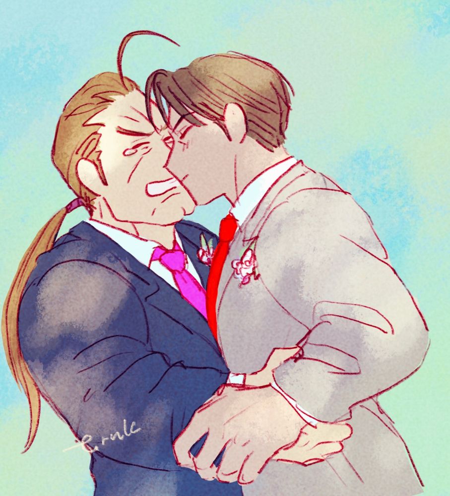 The illustration shows Dan in a navy suit with a pink tie and Guy in a grey suit with a red tie, smiling and kissing. They both have small white flowers on the left side of their chests. Guy holds Dan's arm and pulls him towards them, while Dan has his hand on Guy's waist. Dan is in tears.