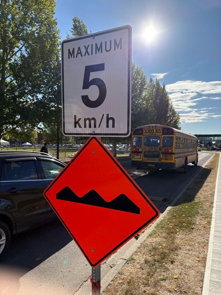 A sign saying the speed limit is 5 kilometres per hour, with another sign below it warning of speed bumps