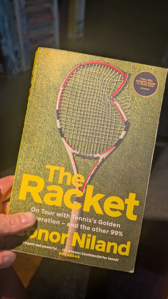 A cover of a book called The Racket, author is Conor Niland. There is a broken tennis racquet on the cover of the book. 