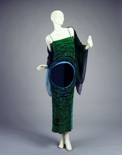 mannequin in emerald green and sapphire blue dress and shawl, hands popped out a little like she's gonna launch into the charleston