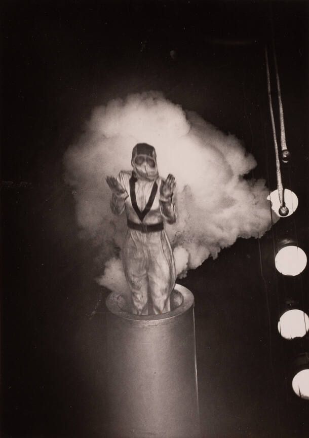 a person in a flight suit of sorts in the process of being shot out of a cannon, a cloud of smoke around them Weegee 1943 Cornell University collection 