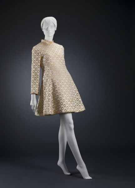 mannequin in long-sleeved midi dress, leaning back all cool like there's a hot guy in front of her and a brick wall behind her