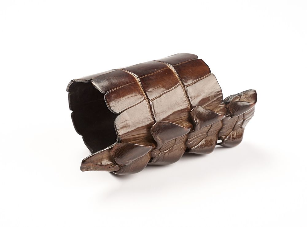 shiny brown cuff bracelet with a serpentine spine along one side