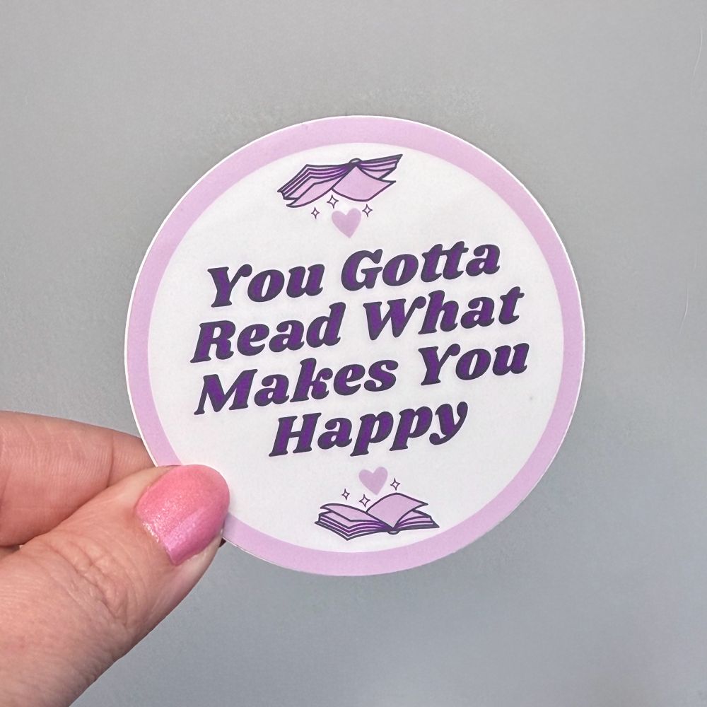 Photo of a round sticker that reads “you gotta read what makes you happy” 