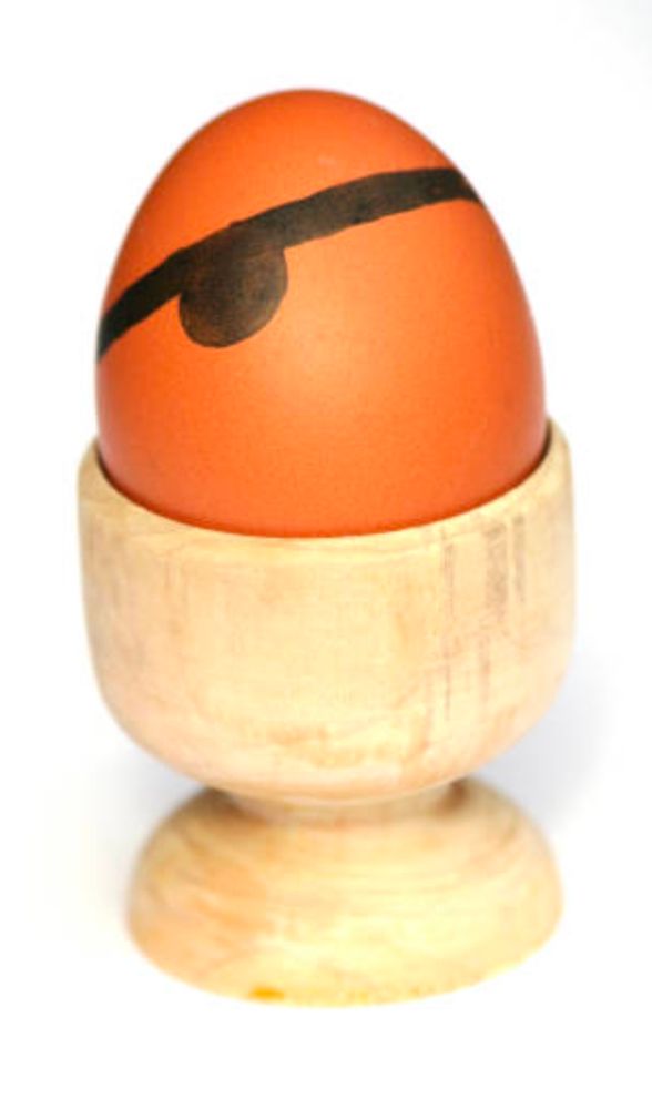 Egg with a painted eye patch in an egg cup