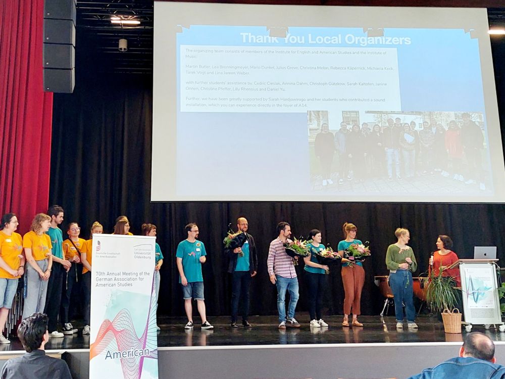 Photo of a stage filled with people holding flowers. A slide reads: Thank you Local organizers!