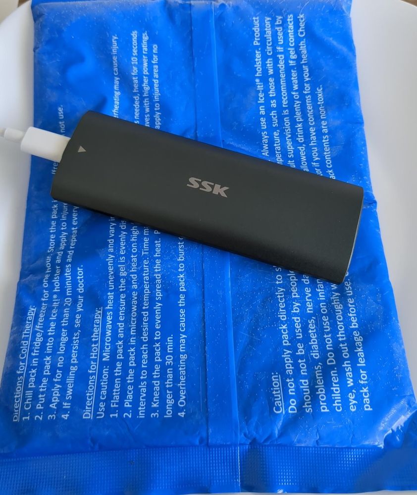 A metal external m.2 enclosure sitting on an ice pack