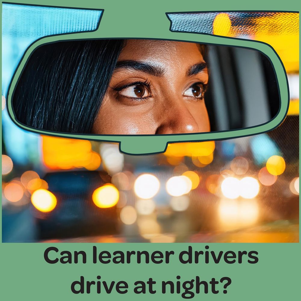 Young girl driving at night in a busy town, you can see the reflection of the girl driving in her rear view mirror