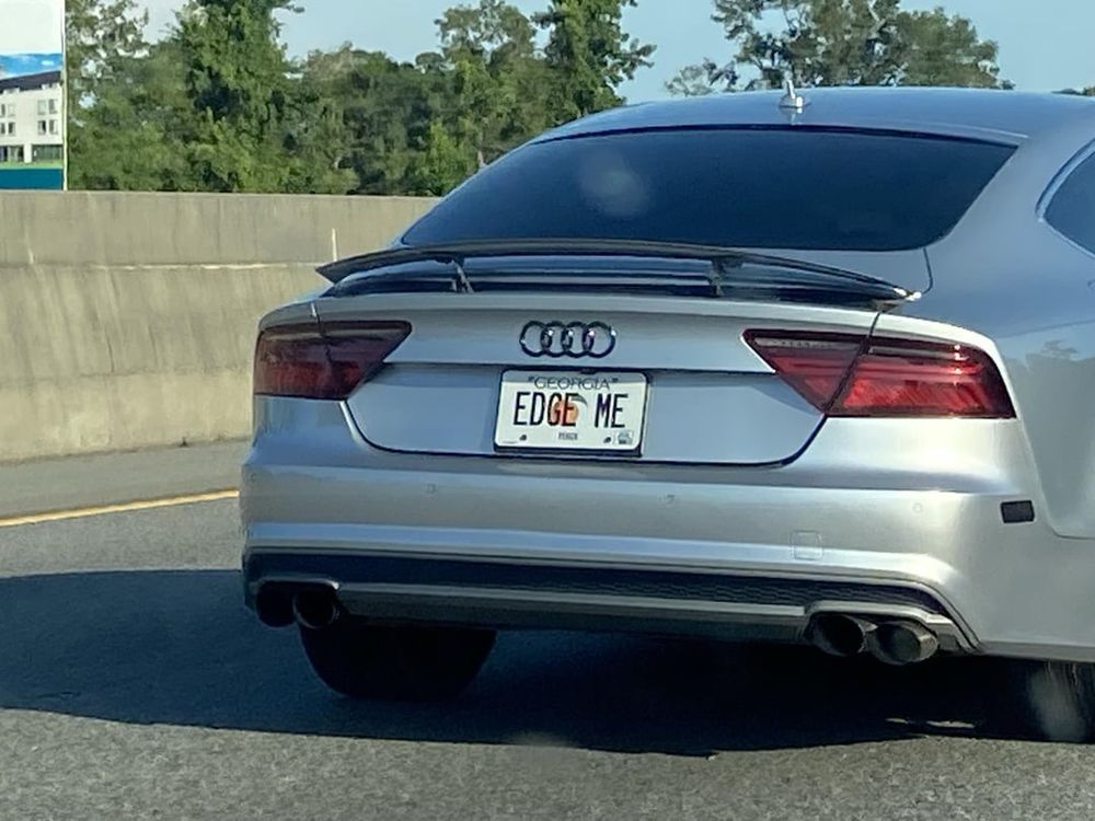 A photo of the back of a silver-colored Audi car. The Georgia license plate reads: EDGE ME