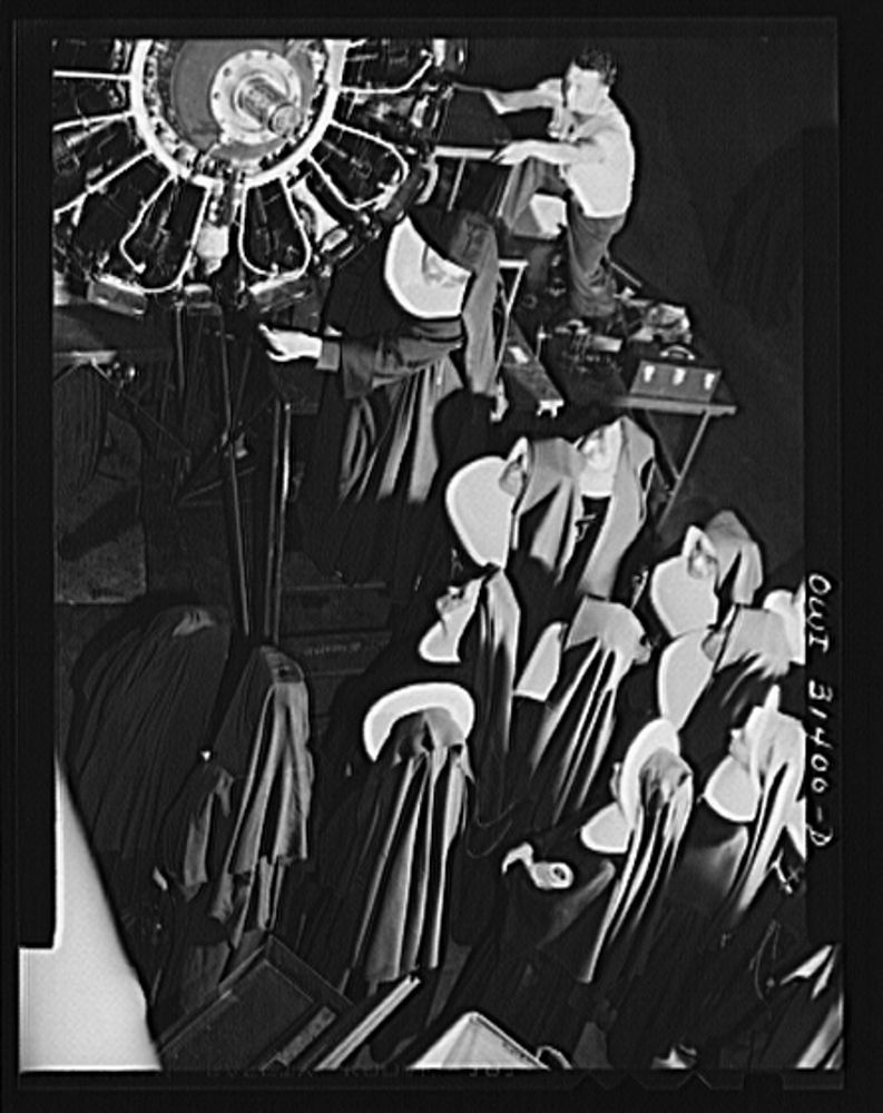 Old image of nuns looking up at a radial engine.