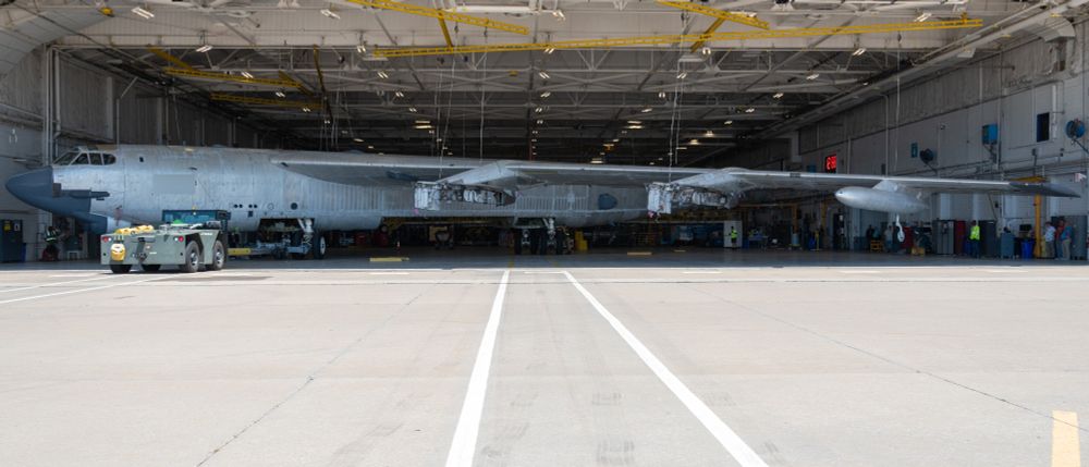 A B-52H Stratofortress undergoing programmed depot maintenance is towed into a hangar at Tinker Air Force Base, Oklahoma, July 28, 2025. The aircraft’s extra-long wingspan is too wide for the hangar, so it “crabs” into the hangar diagonally. Representatives from Boeing were on hand for this towing to study how the Oklahoma City Air Logistics Complex moves the B-52 as the company prepares for Commercial Engine Replacement Program upgrades. (U.S. Air Force photo by Courtney Landsberger)