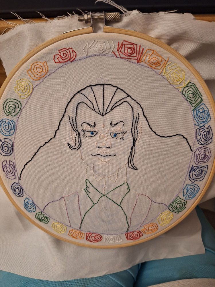 An embroiderex image of a longhaired man surrounded by a rainbow of roses.