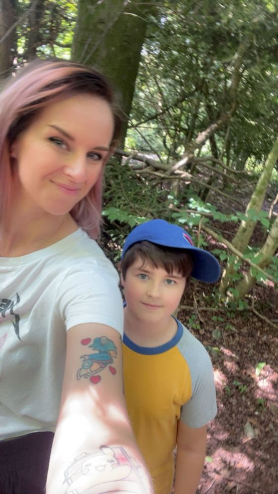 Smiling woman with pink hair and smiling boy with blue cap