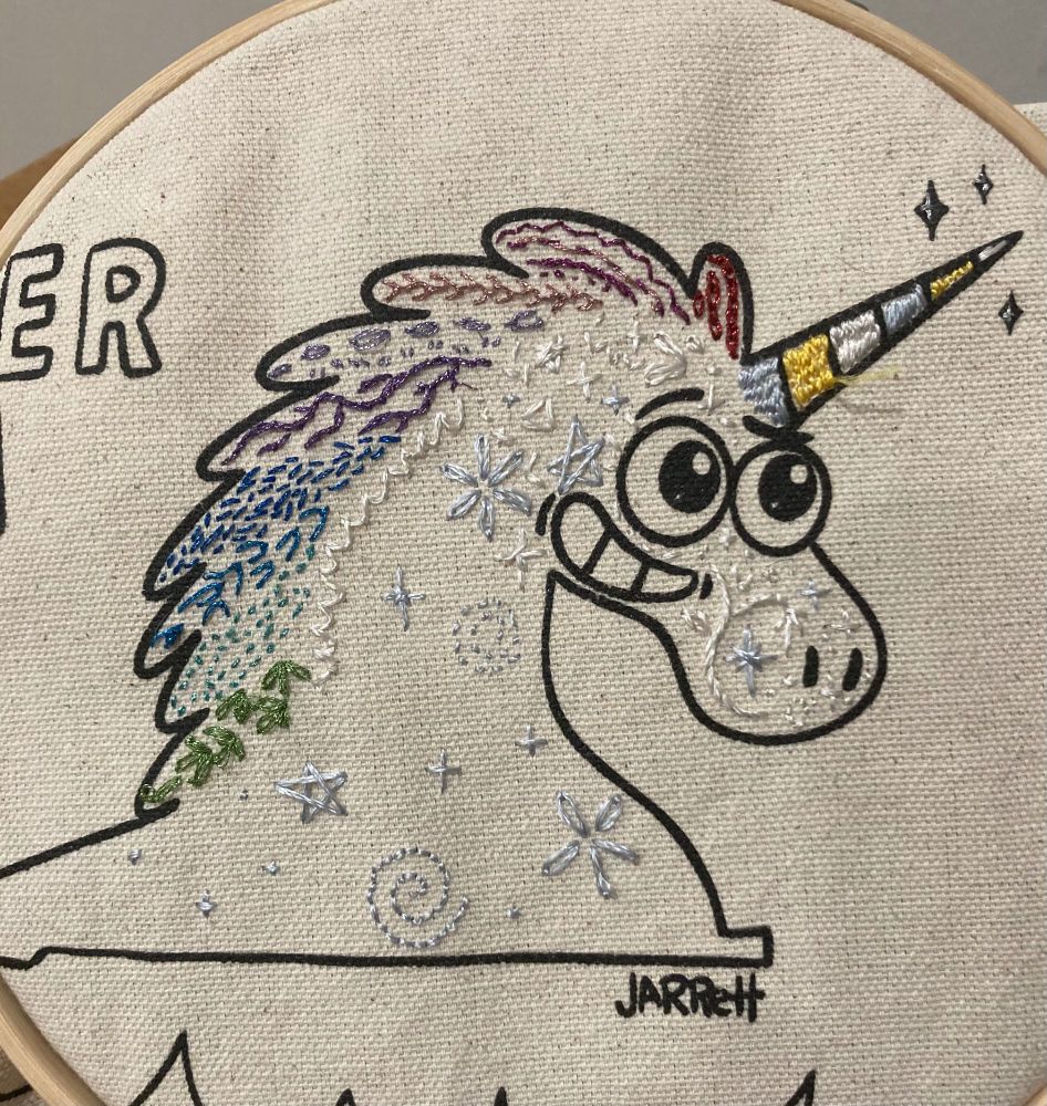 a unicorn head with a bunch of random embroidery stitches on it