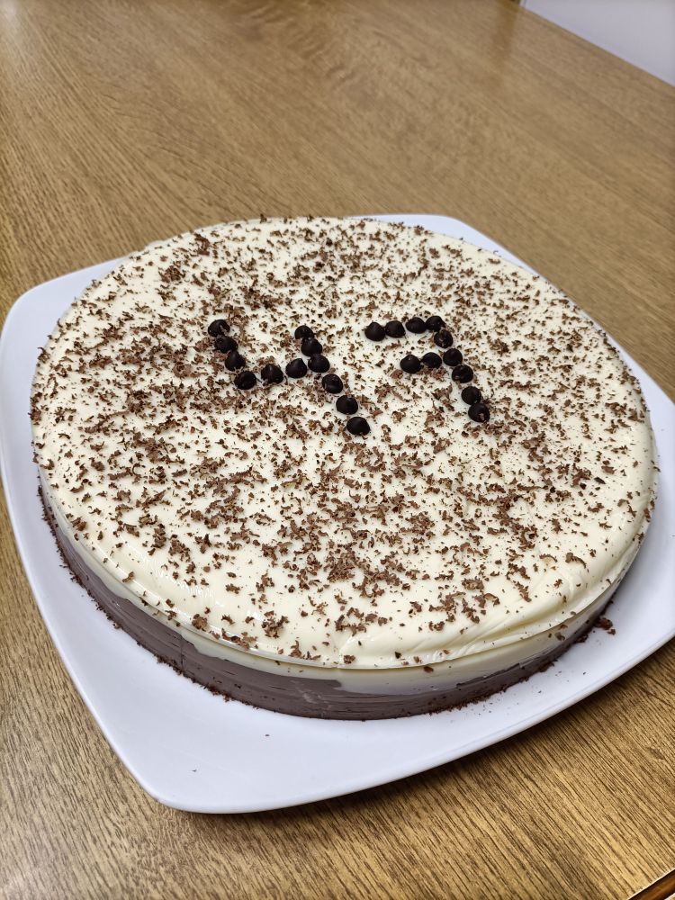 Torta de tres chocolates, leva unhas migas de chocolate e un número 47 como decoración. A primeira capa é de chocolate branco, a segunda de chocolate con leite e a derradeira de chocolate negro.