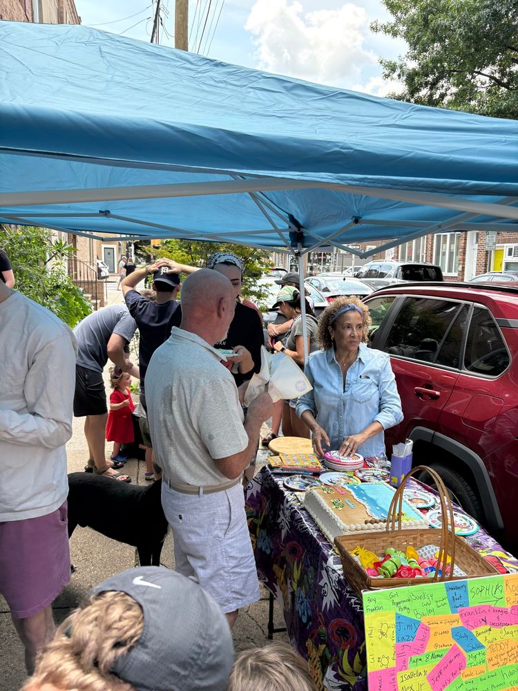 Neighbors gather to cut the turtle cake 
