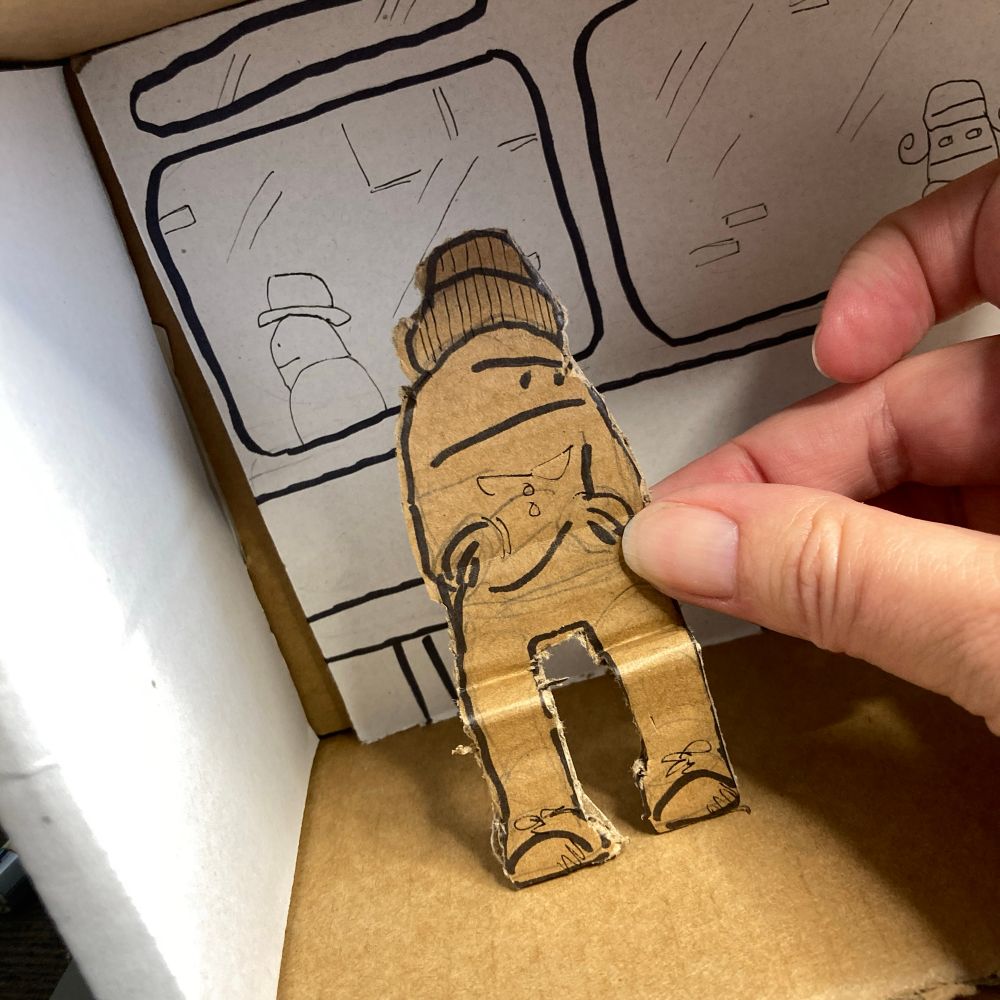 Photo of placing a cardboard character into a model of a bus