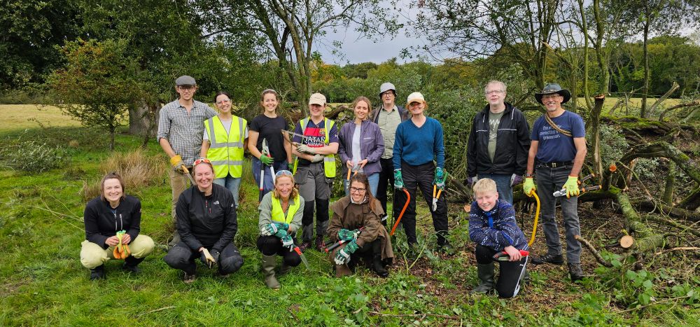 A team of crazy pond restorers in a pond in a meadow
