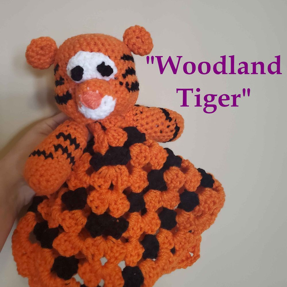 A crochet tiger lovey which looks a little too similar to Tigger of the Winnie the Pooh universe. Text reads: "woodland tiger."