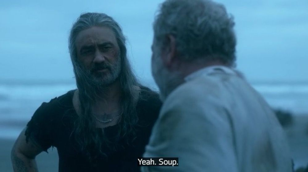 Ed Teach and Hornigold from our flag means death standing on a beach. The shot is angled facing Ed, and you can see the sea behind him. He’s giving Hornigold an odd look and saying “yeah. Soup.”