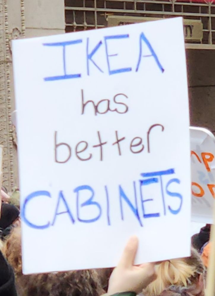 A sign reading "IKEA has better cabinets"