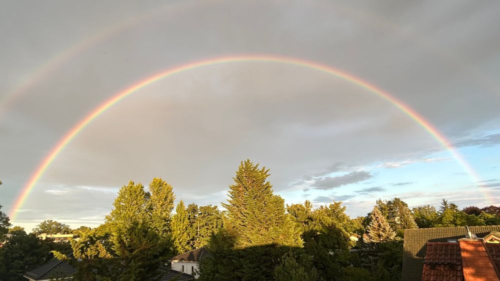 Perfekter Regenbogen im Himmel über Berlin