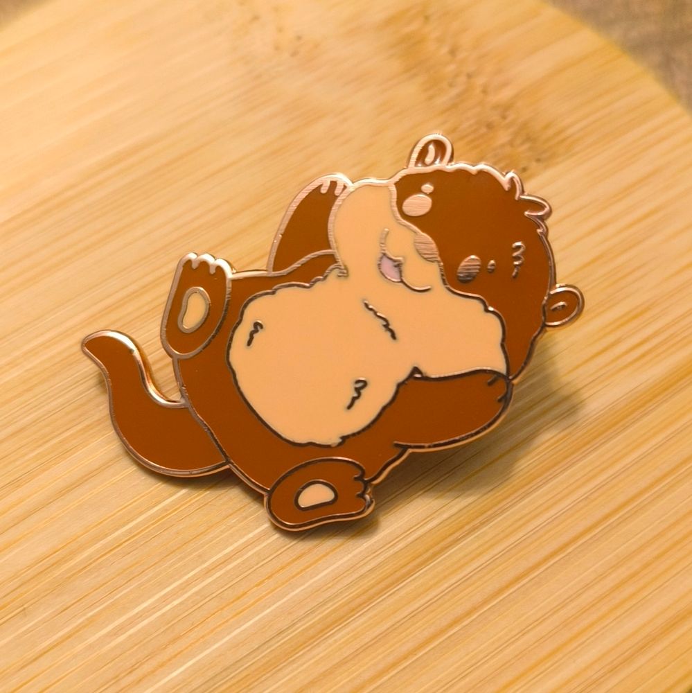Opie the Otter. Cute hard enamel pin of an otter on his back.
