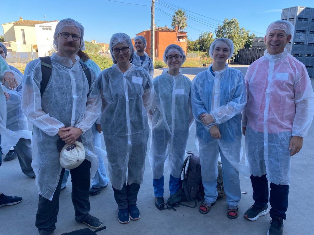 5 Cambridge scientists in protective gear before a tour of sustainable apple production facilities