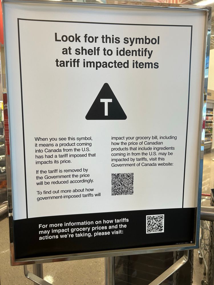 Big signage entering a superstore in Ontario today.
“Look for this symbol at shelf to identify tariff impacted items “ and shows  a white capital T inside of a black triangle. There’s also a scan code for more info
