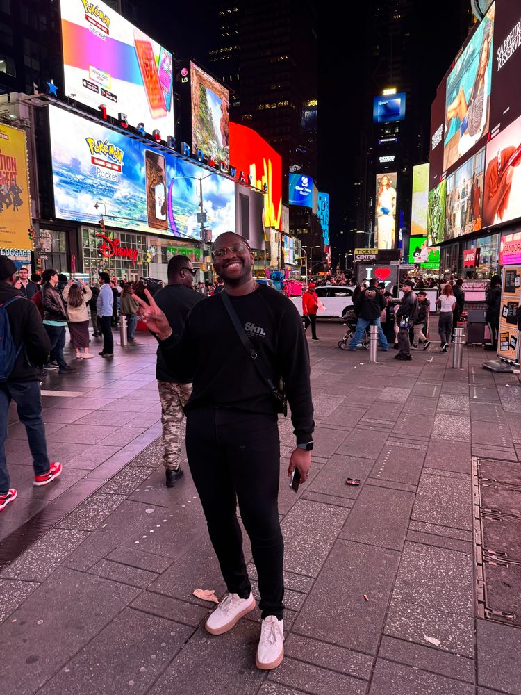 Myself wearing all black with white shoes in the middle of Times Square.