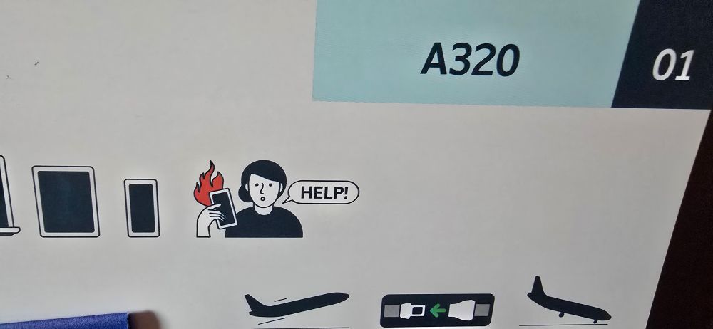 Sicherheits Karte im Flugzeug. Eine Person hält ein brennendes Handy. In einer Sprechblase steht Help.