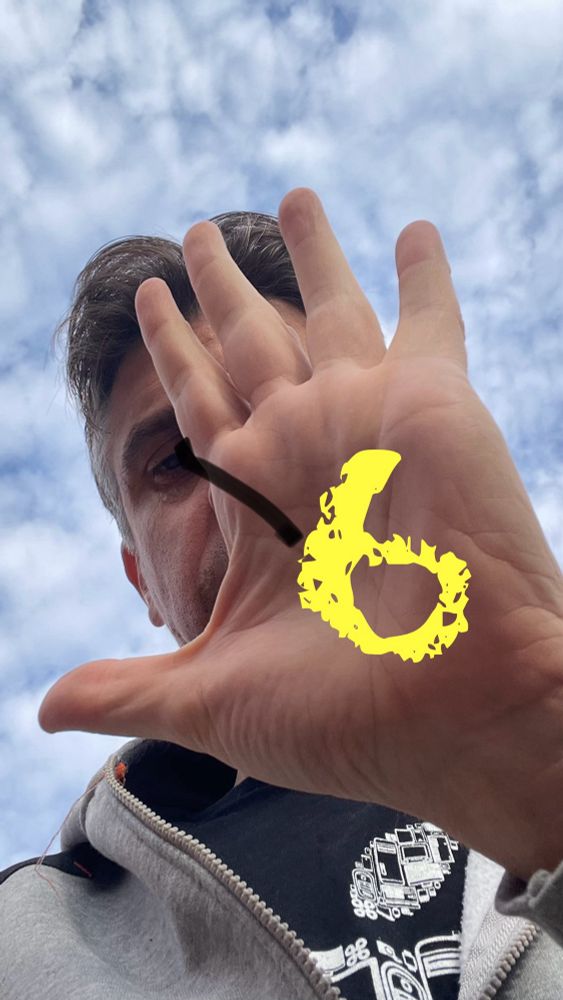 Manu zeigt sein Hand (Also „fünf“) und darauf steht ein 6 geschrieben