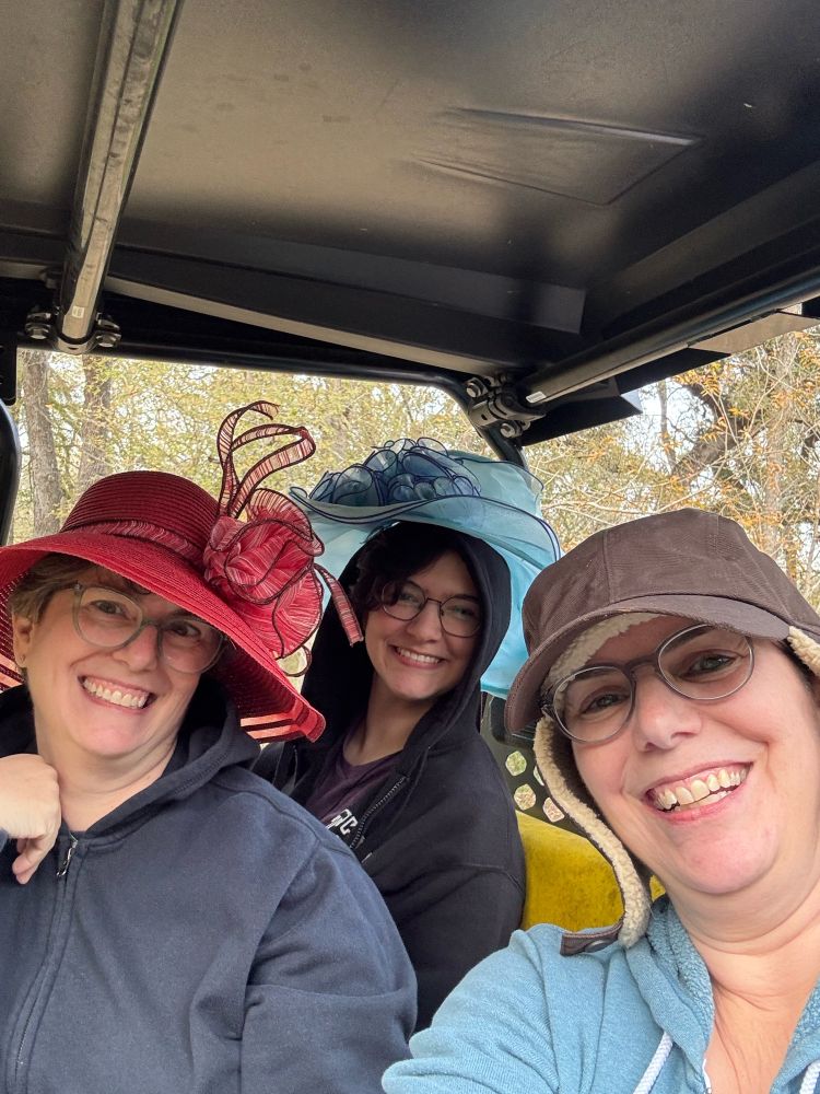 Two 50-something sisters and a teen in fanciful garden and ear flap hats