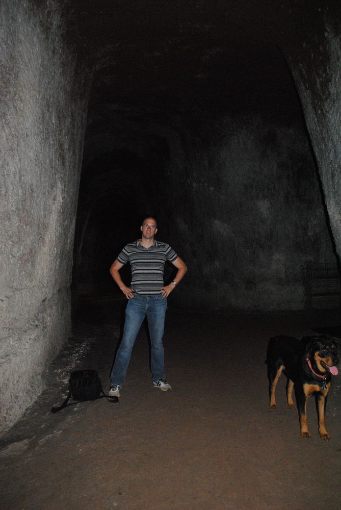 Me standing in a large gallery of an ancient Roman tufa quarry on private property off the Via Appia in Rome, plus my friend’s old dog Nyla.