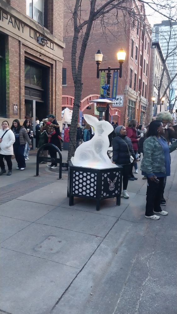 Plexiglass sculpture of a bunny, at a busy street.
