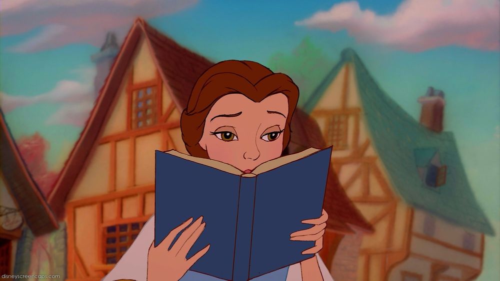 Belle from Beauty and the Beast holding up a book to read.