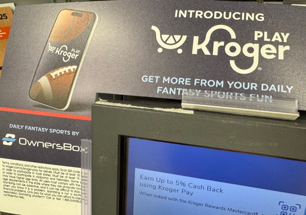 A Kroger grocery store advertisement posted on a self-checkout station, promoting the “PlayKroger” sports betting app - some kind of licensed gambling app services through the OwnersBox platform. 