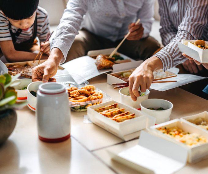 Multiple takeout containers full of food on a table.