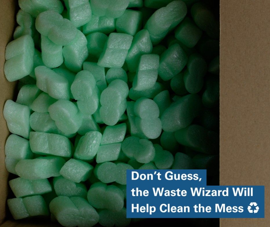 Photo of a box filled with green Styrofoam packing peanuts. 