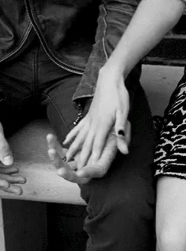 a black and white photo of a couple holding hands