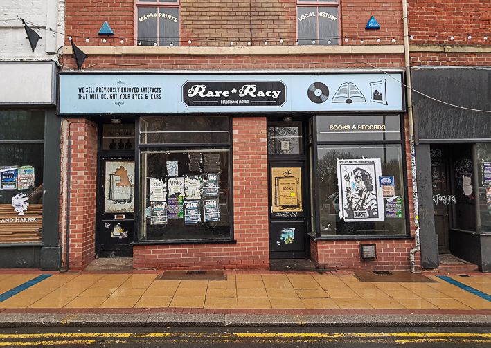 Photograph of a once iconic book and recoord shop in Sheffield (UK). The shop has closed down and it looks abandoned and forlorn. The windows are covered with battered events posters.