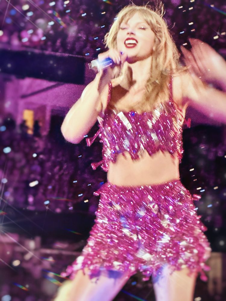 Taylor Swift on stage at the eras tour during the 1989 set. She’s wearing the original pink outfit. 