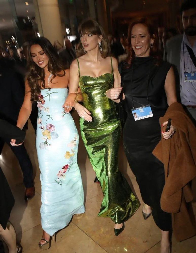 Taylor and Keleigh walking arm in arm with Tree Paine. Tree is dressed in a classy and modest black dress and carrying her brown coat. She has a press pass around her neck. 